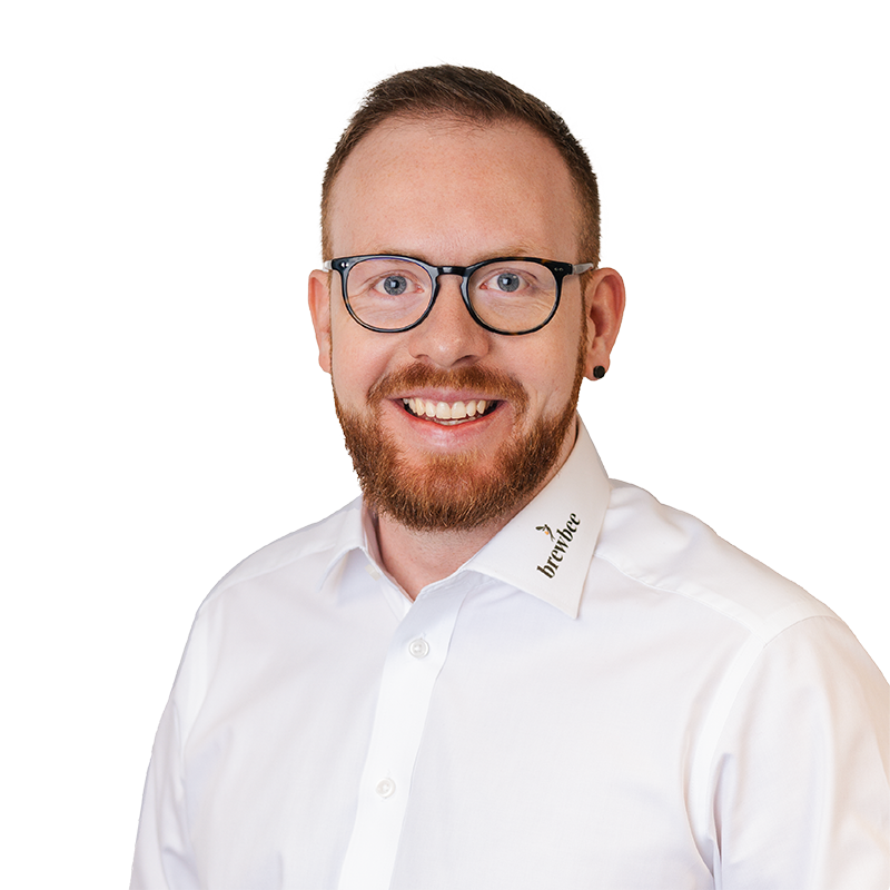 Porträt eines lächelnden Mannes mit Brille und Bart im weissen Hemd vor hellem Hintergrund – ideal für Teamseiten oder Unternehmensprofile.