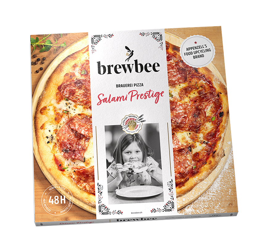 Verpackung einer Brewbee Salami Prestige Pizza, zeigt eine frisch belegte Pizza mit Salami und Käse, mit nachhaltiger Verpackung und 48 Stunden Frische, relevant für Food Upcycling.
